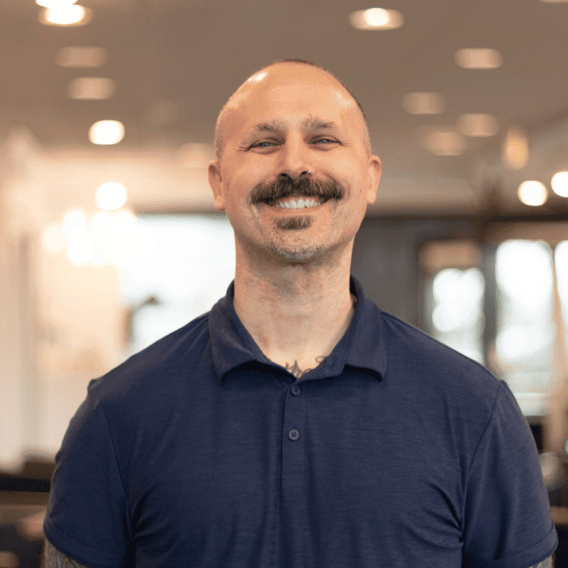 Portrait of Nicholas, a professional stylist at Brassfields Salon and Day Spa, showcasing their expertise and style.