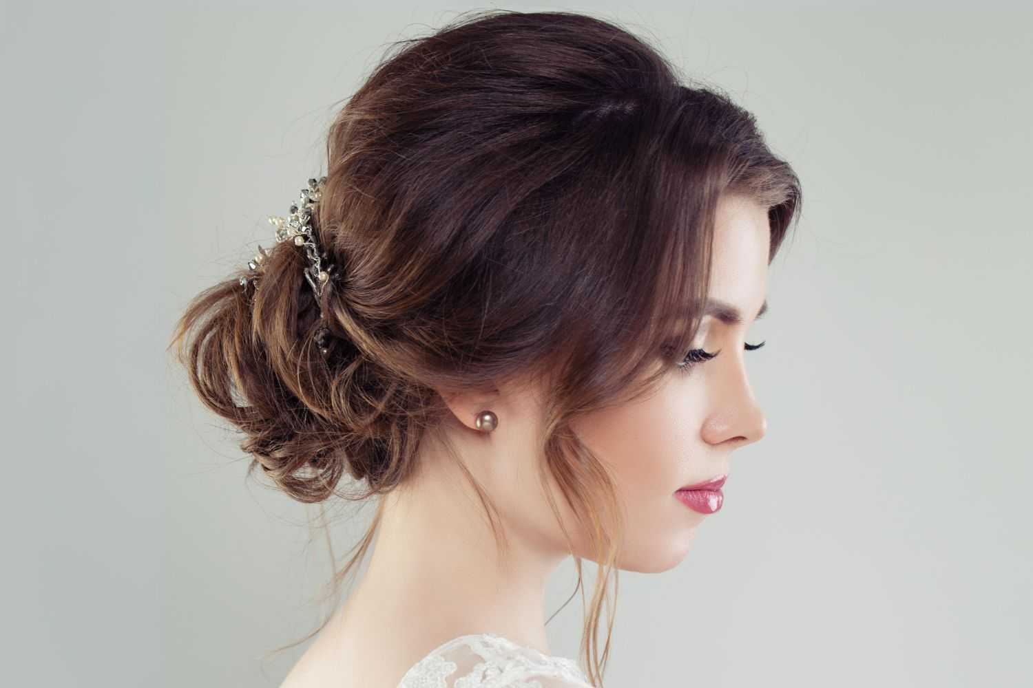 Woman with an elegant updo hairstyle adorned with decorative hairpins, side profile.