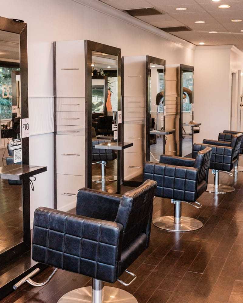 Modern hair salon with empty styling chairs and mirrors.