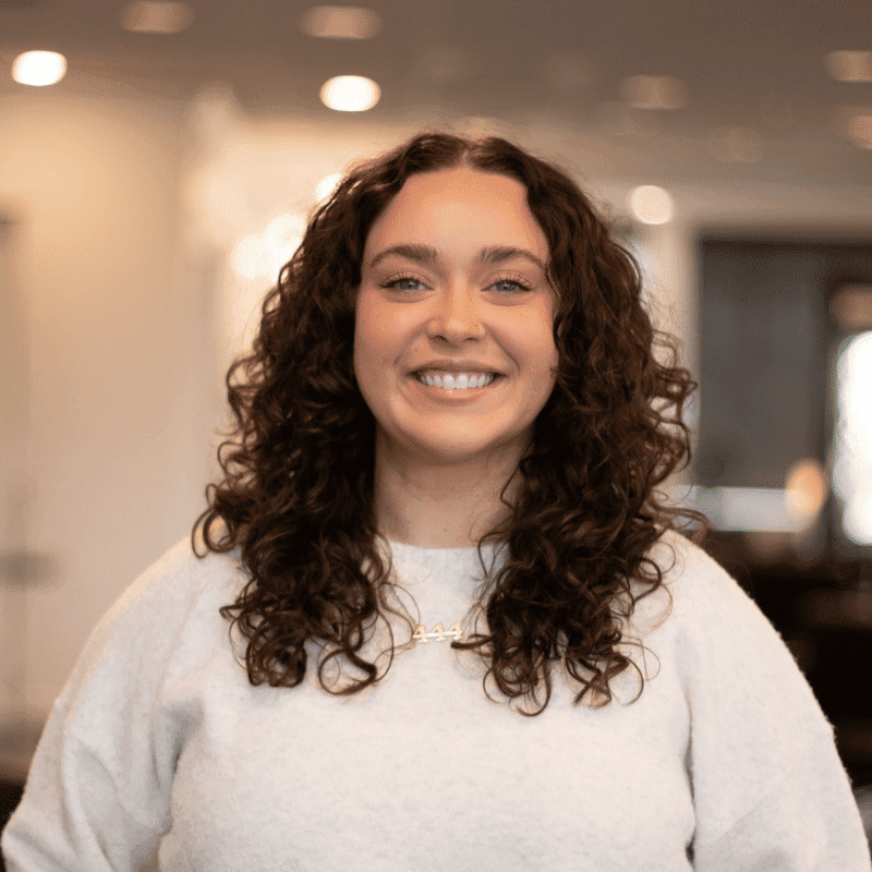 Portrait of Bailey, a professional stylist at Brassfields Salon and Day Spa, showcasing their expertise and style.